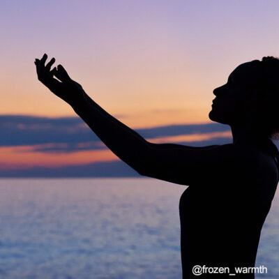 Silueta de una chica practicando la meditación con el mar de fondo